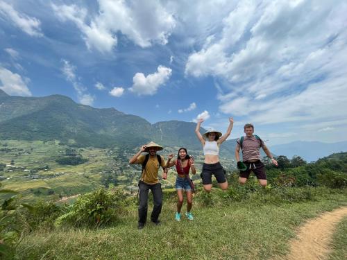 um grupo de pessoas em pé no topo de uma colina em SaPa Big Tree Hmong Homestay em Sapa