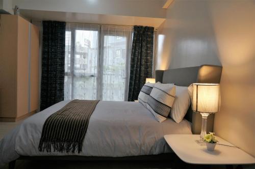 um quarto com uma cama grande e uma janela em Eighty One Building C53J Condotel em Manila