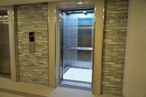 um chuveiro com uma porta de vidro num edifício em Eighty One Building C53J Condotel em Manila