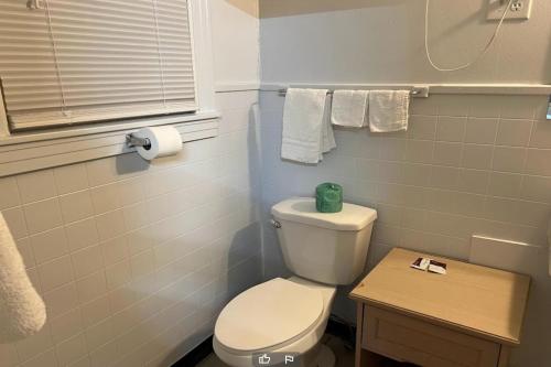 a bathroom with a toilet and a table and towels at Anson Inn By OYO in Anson