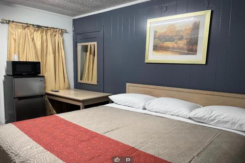 1 dormitorio con 1 cama con pared azul en Anson Inn By OYO, en Anson