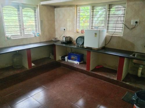 uma cozinha com um balcão e um frigorífico em Samz estate stay 2BHK em Madikeri