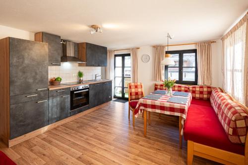 cocina y sala de estar con mesa y sofá en Schittlerhof, en Fischen