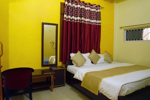 a bedroom with two beds and a desk and a mirror at Atithi Hotel in Paliā Kalān
