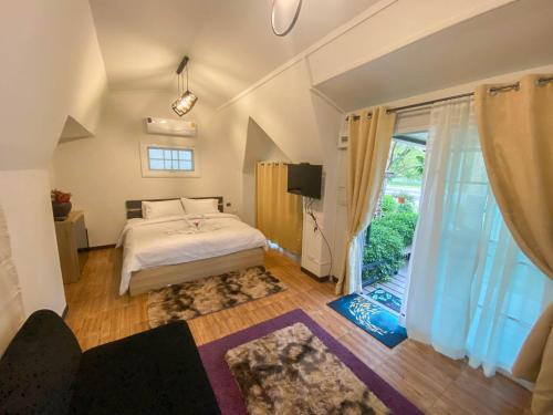 um quarto com uma cama e uma grande janela em Baan Nimit Resort 