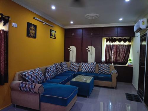 a living room with blue couches in a room at Duplex house homestay near Vijayawada, Tadepalli in Vijayawāda