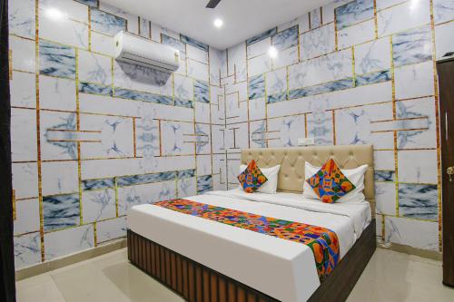 een slaapkamer met een bed en een betegelde muur bij FabExpress Cash in Mohali