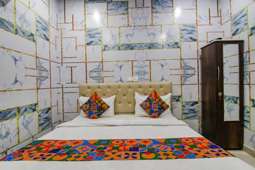 een slaapkamer met een bed en een muur bedekt met tegels bij FabExpress Cash in Mohali