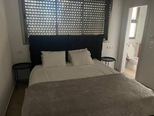 1 dormitorio con 1 cama grande y 2 mesas en Beach Apartment - Ramat Aviv en Tel Aviv