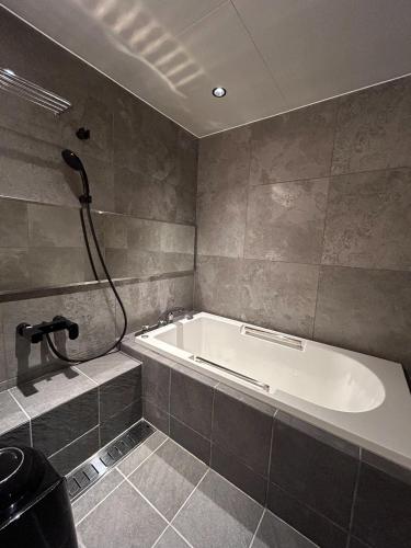 a bathroom with a bath tub and a shower at PAYSAGE MORIGUCHI - Vacation STAY 32994v in Mima