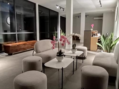 una sala de estar con sofás, sillas y flores en las mesas. en ONYX HOTEL & VILLA en Tanjunguban