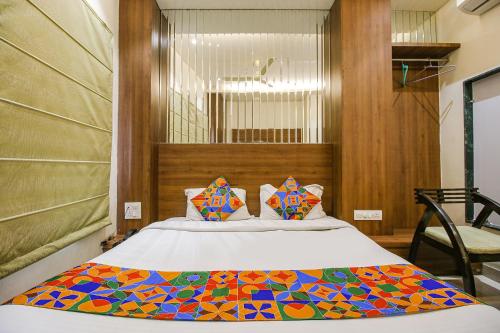 Un dormitorio con una cama con una manta de colores. en FabHotel Royal Palace II, en Bhopal