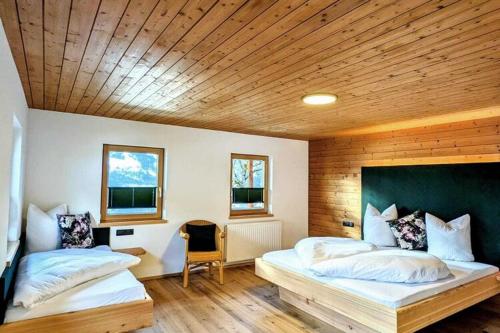 a bedroom with two beds and a wooden ceiling at Spacious holiday home in Distelberg with sauna in Aschau