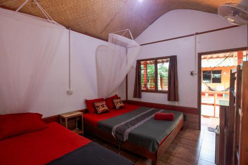 ein Schlafzimmer mit einem Bett und einem Sofa in einem Zimmer in der Unterkunft Family Song Koh Lipe in Ko Lipe