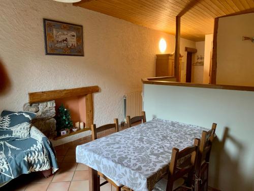 - une salle à manger avec une table et un lit dans l'établissement La Tourtette, à Saint-Étienne-en-Dévoluy