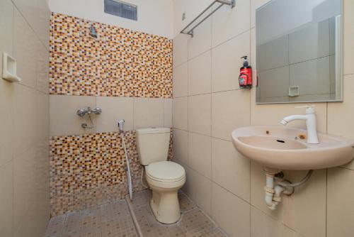 a bathroom with a toilet and a sink at RedDoorz near Bojonegoro Train Station in Bojonegoro