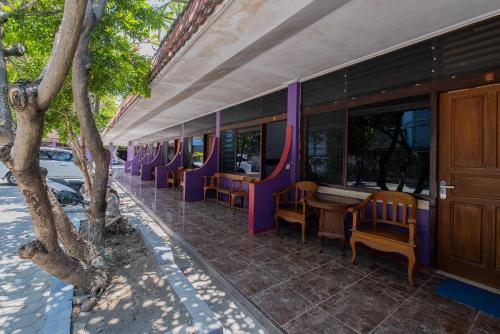 a train car with purple chairs and a table at RedDoorz near Bojonegoro Train Station in Bojonegoro