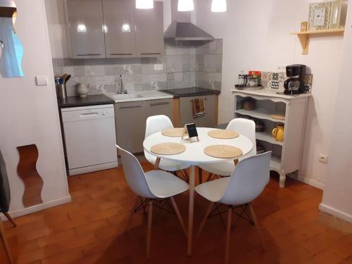 une cuisine avec une table et des chaises dans une cuisine dans l'établissement Maison chaleureuse près de lagrasse corbières, à Saint-Pierre-des-Champs