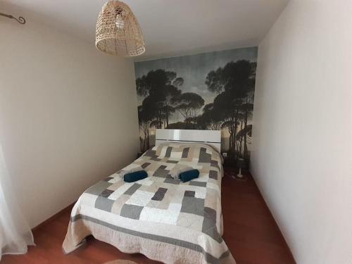 1 dormitorio con 1 cama y una pintura en la pared en Maison chaleureuse près de lagrasse corbières, en Saint-Pierre-des-Champs
