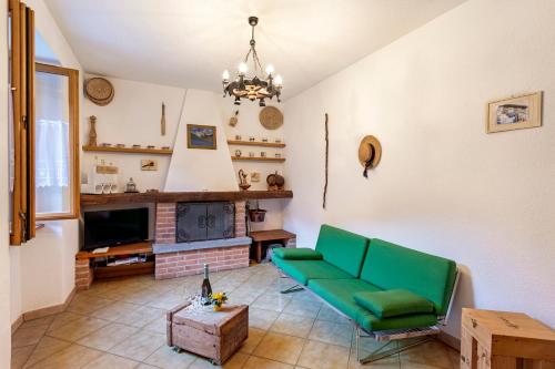 a living room with a green couch and a tv at Casa Lara - Happy Rentals in Lugano