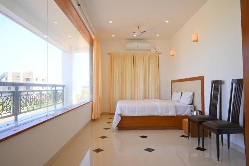 ein Schlafzimmer mit einem Bett und einem Balkon in der Unterkunft Villa Happiness in Puducherry