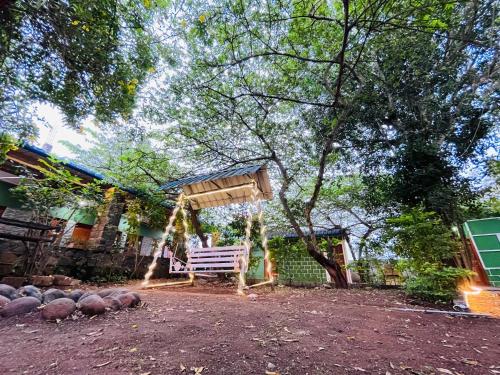 un banco de madera sentado frente a una casa en SPM Residency, From Live2Travel Group. en Masinagudi