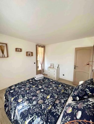 Schlafzimmer mit einem Bett mit blauer Decke in der Unterkunft Maison Climatisée in Saint-Hippolyte