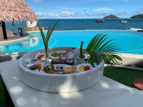 a tray of food on a table next to a pool at DD Hut Koh Tao in Ko Tao