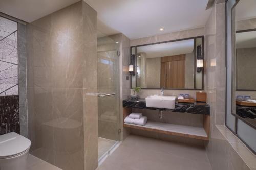 a bathroom with a shower and a toilet and a sink at Nysa Hotel Bangkok Sukhumvit 11 in Bangkok