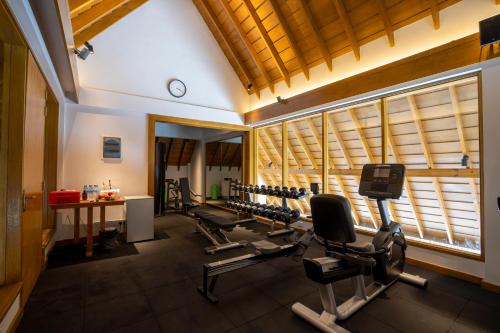 a gym with a row of treadmills and machines at Emerald Faarufushi Resort & Spa - Deluxe All Inclusive in Raa Atoll
