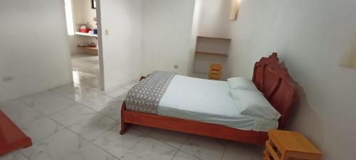 1 dormitorio con 1 cama en una habitación blanca en Casa de campo en Bellavista en Puerto Ayora
