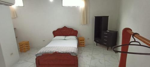 a small bedroom with a bed and a dresser at Casa de campo en Bellavista in Puerto Ayora