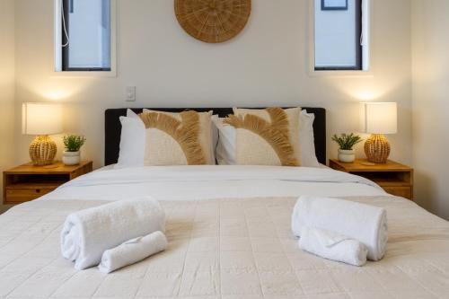 Un dormitorio con una gran cama blanca con dos almohadas. en New Brighton Beach Explore - King Bed and sofa bed, en Christchurch