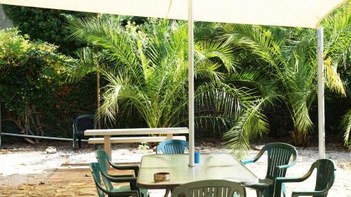 a table and chairs with an umbrella and a bench at Golden Leaf Motel in Myrtleford