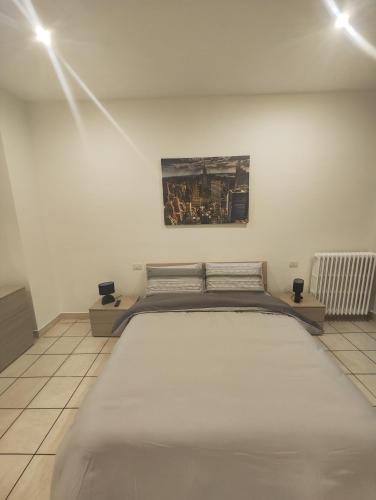 sypialnia z dużym łóżkiem i obrazem na ścianie w obiekcie Appartamento c&y Monte san Gabriele w mieście Novara