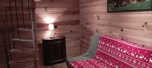 Habitación con pared de madera, escalera y banco. en La chambre Nature chez les garçons en Saint-Paul-sur-Yenne