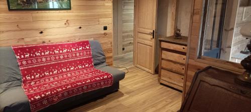 een kamer met een bed met een rode deken erop bij La chambre Nature chez les garçons in Saint-Paul-sur-Yenne