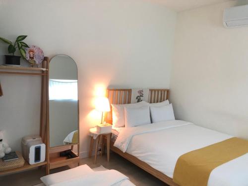 a small bedroom with two beds and a mirror at Yangyang, Stay There in Yangyang