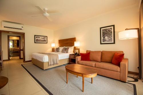 a hotel room with a bed and a couch at Sands Suites Resort & Spa in Flic-en-Flac