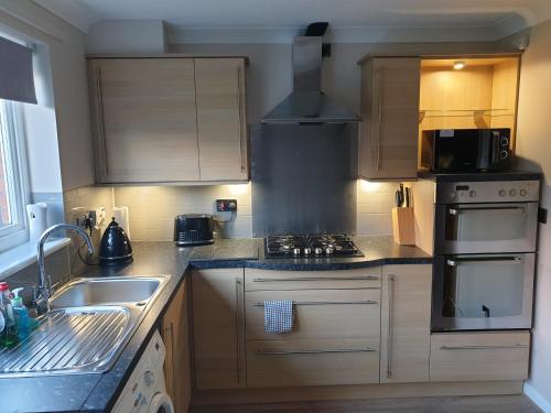 a kitchen with a sink and a stove top oven at Oldwood Place Townhouse in Livingston