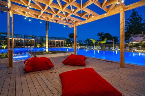 two red bean bags on a patio next to a swimming pool at Tasman Holiday Parks - Papamoa Beach in Papamoa