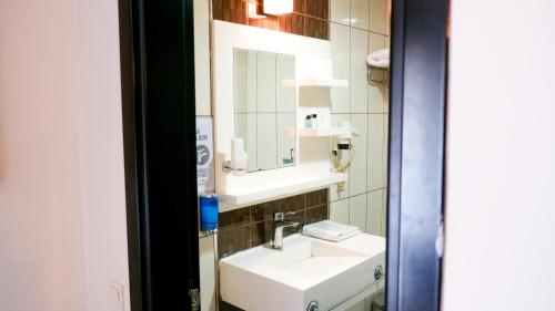 een badkamer met een wastafel en een spiegel bij Hotel La Bella Soma in Soma