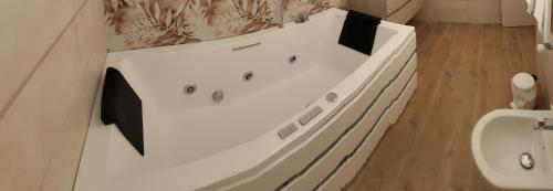 ein Badezimmer mit einer weißen Badewanne und einem Waschbecken in der Unterkunft Villa Nasti Luxury Bed Taurasi Room in Nocera Inferiore