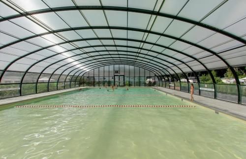 een binnenzwembad met een glazen plafond bij Huisje Novea in Harderwijk