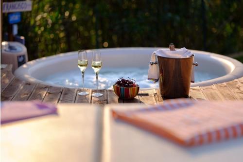 a table with two glasses of wine and a tub at La Luna nel Lago Lake View Garden - Happy Rentals in Ispra