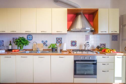 a kitchen with white cabinets and a stove top oven at La Luna nel Lago Lake View Garden - Happy Rentals in Ispra