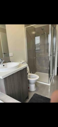 a bathroom with a toilet and a sink and a shower at Cosy Room with lock and work area in Truganina