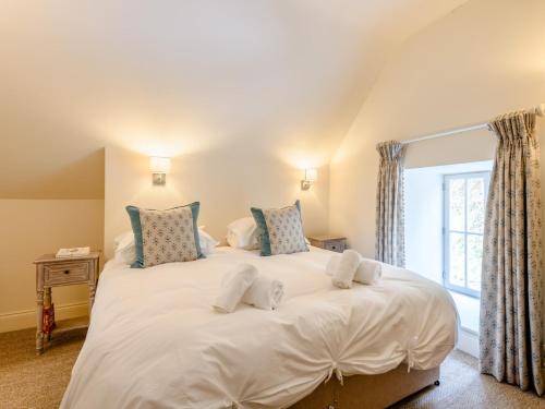 ein großes weißes Bett in einem Zimmer mit Fenster in der Unterkunft 2 Bed in Tisbury 78165 in Tisbury