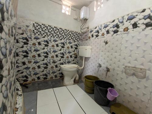 łazienka z toaletą i ścianą wyłożoną kafelkami w obiekcie Salt Desert Homestay w mieście Dhordo