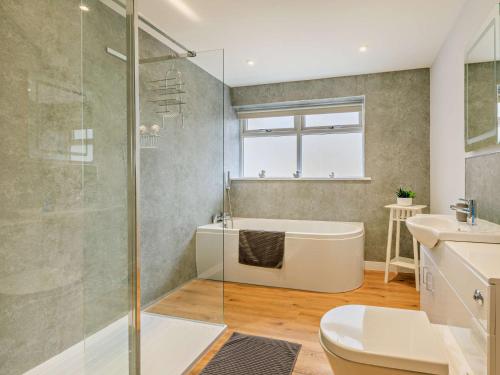 a bathroom with a shower and a tub and a sink at 5 Bed in Charmouth 83584 in Charmouth